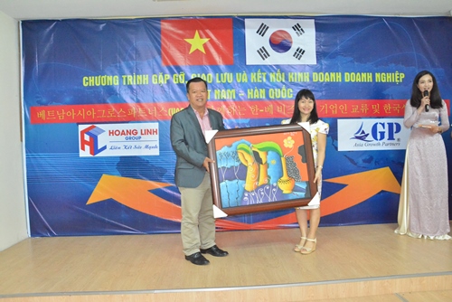 Ông Đặng Hải, Chủ tịch chi hội CLB Doanh nhân Tiên Phong Sài Gòn tặng bức tranh cho bà Lê Thị Hồng, Giám đốc Công ty kết nối Toàn Cầu
