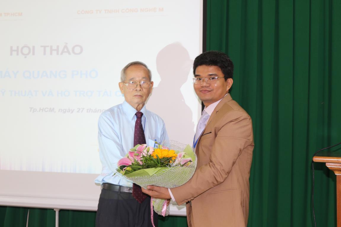 Doanh nhân Lê Văn Thương được Phó Giáo sư, Tiến sĩ Lý Ngọc Sáng trao tặng hoa tại buổi hội thảo máy quang phổ